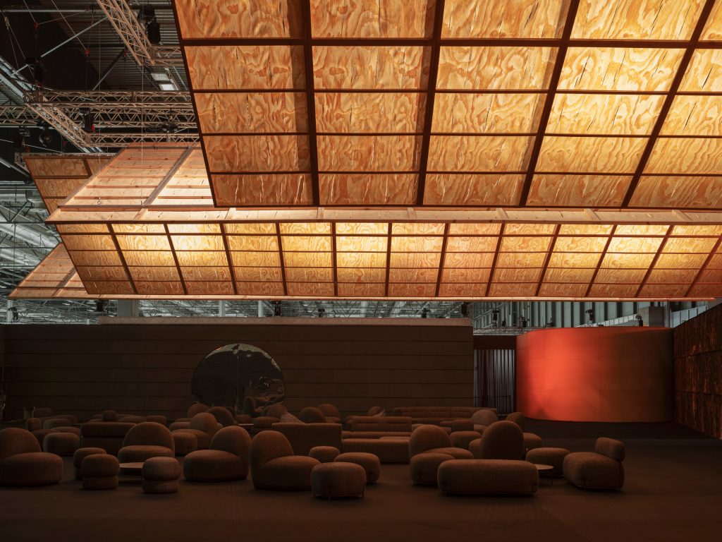 Glowing timber planes suspended over the dark Guest Lounge at ARCOmadrid 2026