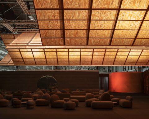 Glowing timber planes suspended over the dark Guest Lounge at ARCOmadrid 2026