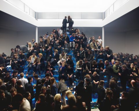 Visitors climb Cyprien Gaillard’s Efes beer bottle pyramid at KW Berlin