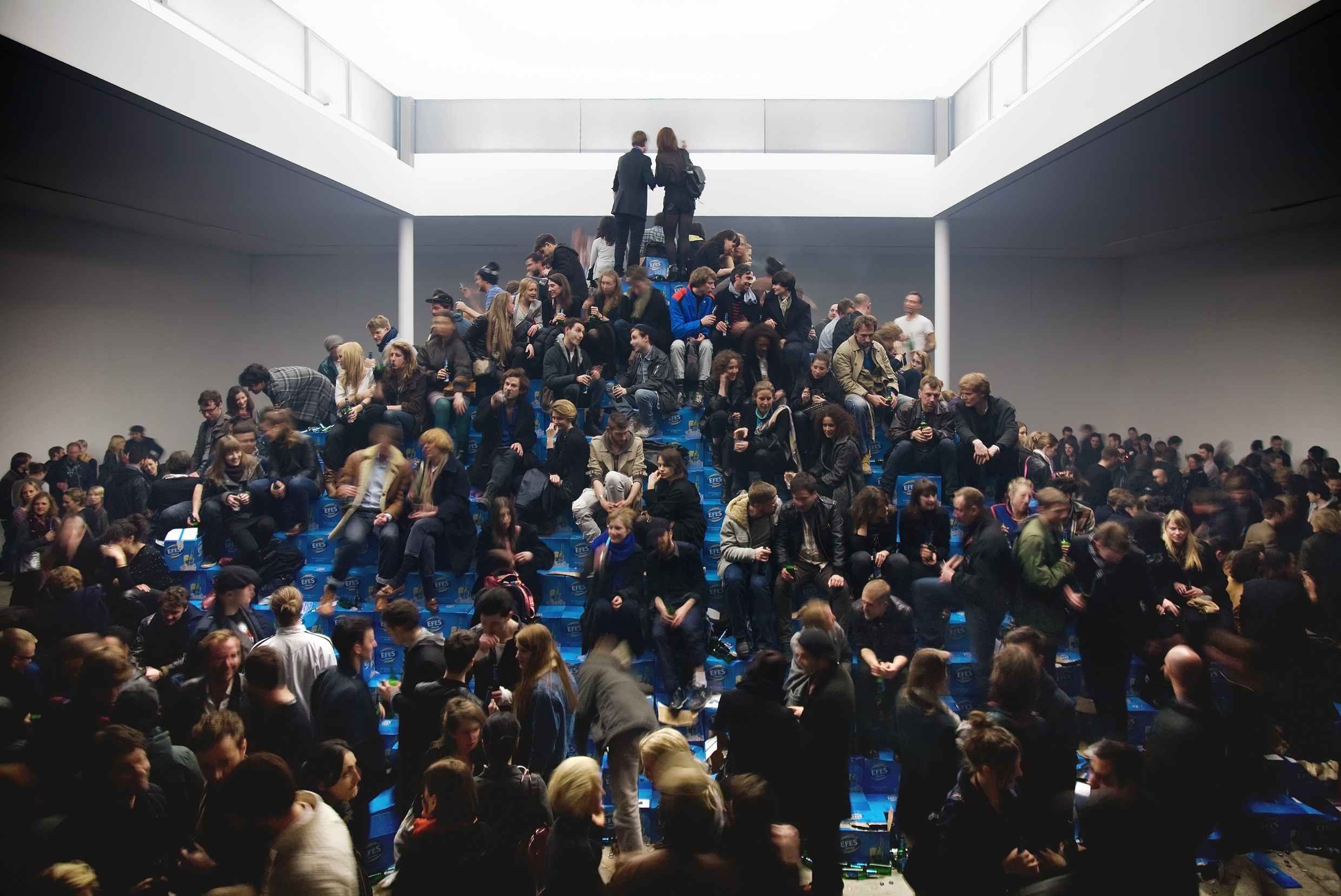 Visitors climb Cyprien Gaillard’s Efes beer bottle pyramid at KW Berlin
