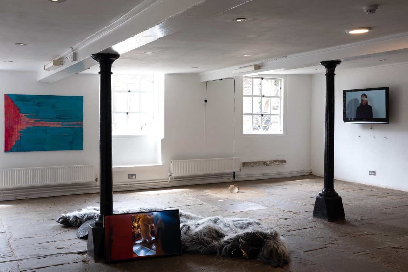 Installation with a fur form and a screen in a white room