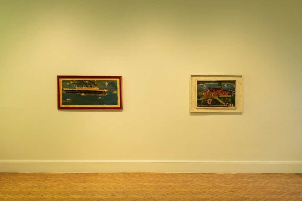 Paintings hung on a pale yellow wall
