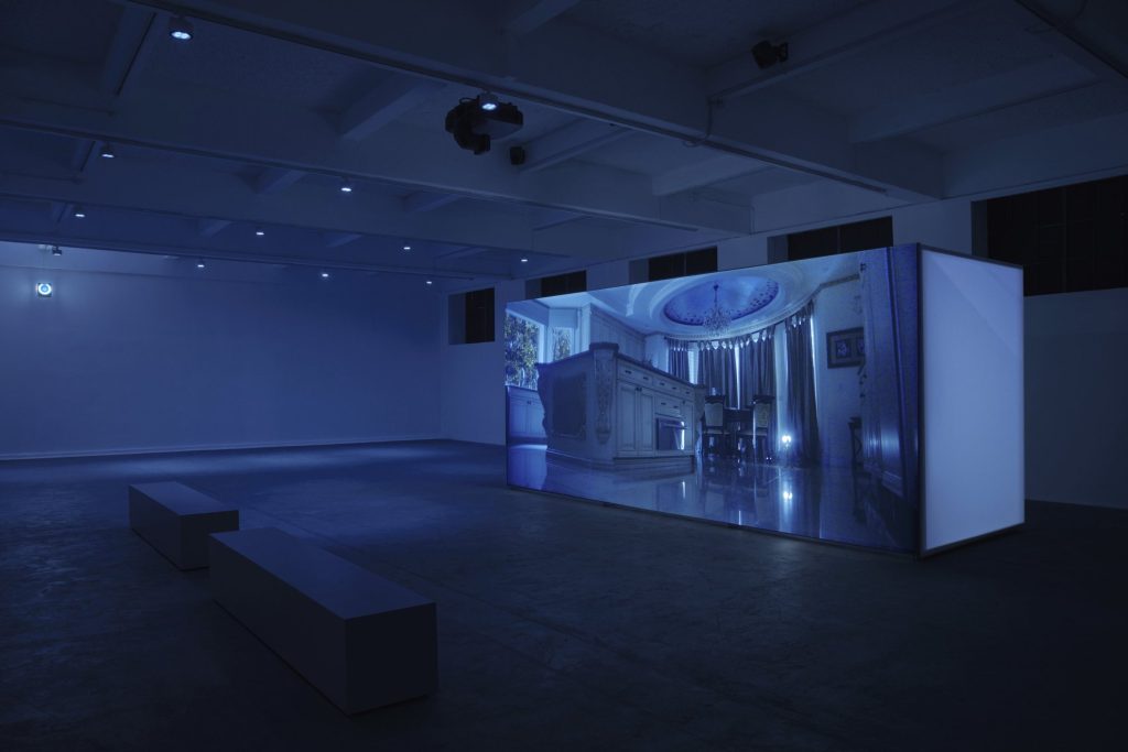 Projection seen across a dark room with benches