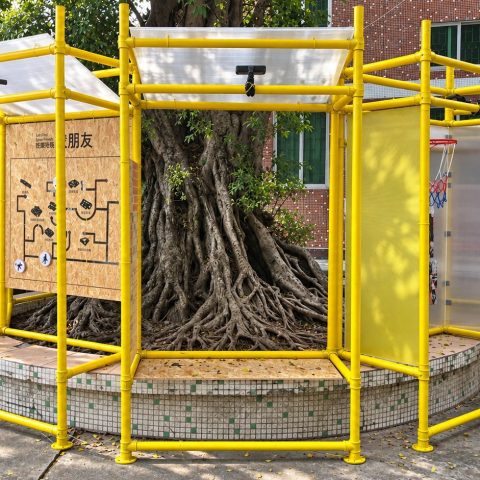 Haogang Ji: yellow scaffolding pavilion around a banyan tree on the former sports ground