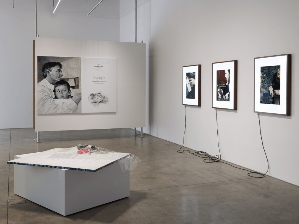 Framed photographs and a low plinth in a gallery