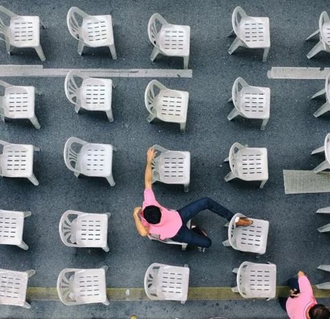 Rows of white monobloc chairs seen from above