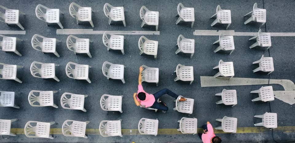 Rows of white monobloc chairs seen from above