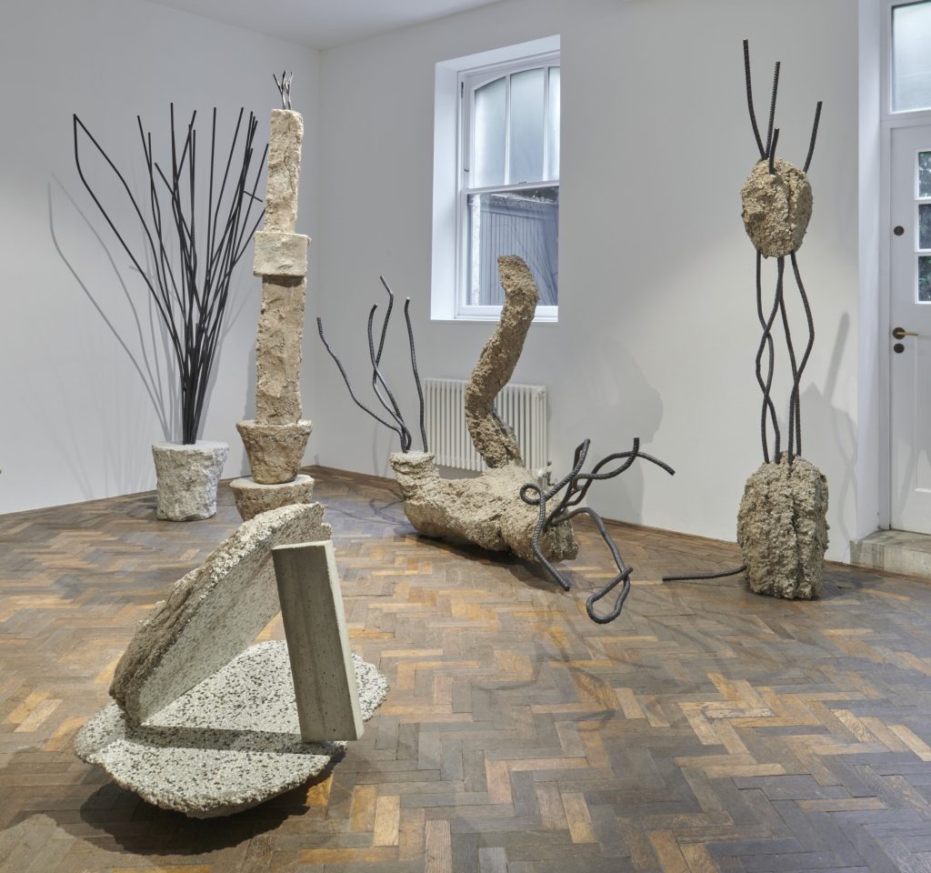 Monika Sosnowska sculptures in a room with tall windows