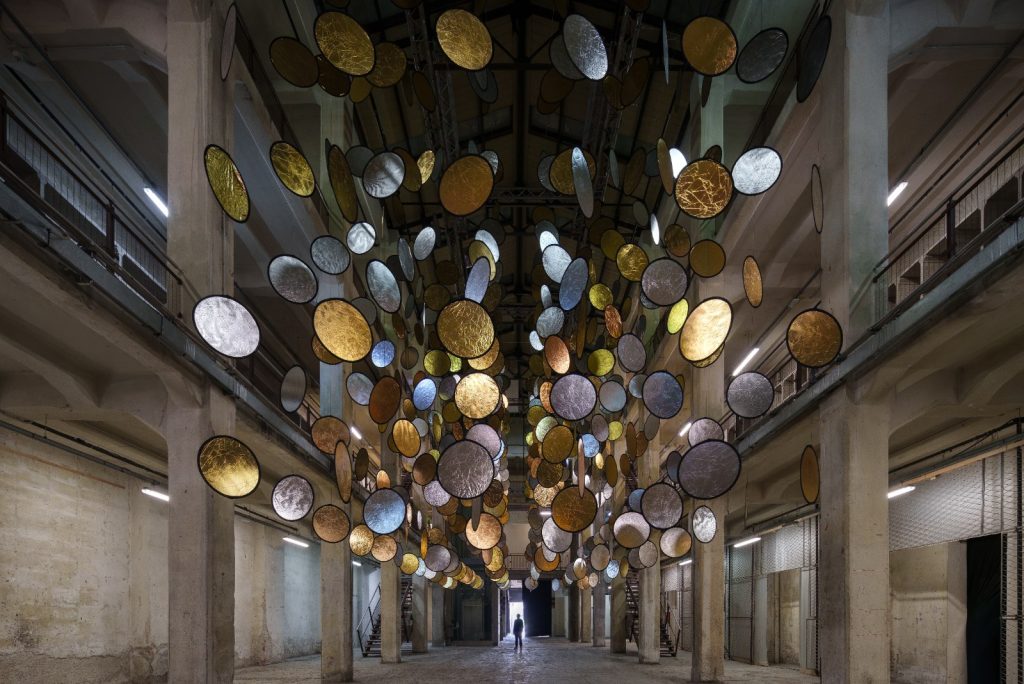 SpY, HALOS, gold and silver reflective circles suspended in a former railway factory in Florence