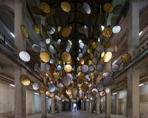 SpY, HALOS, gold and silver reflective circles suspended in a former railway factory in Florence