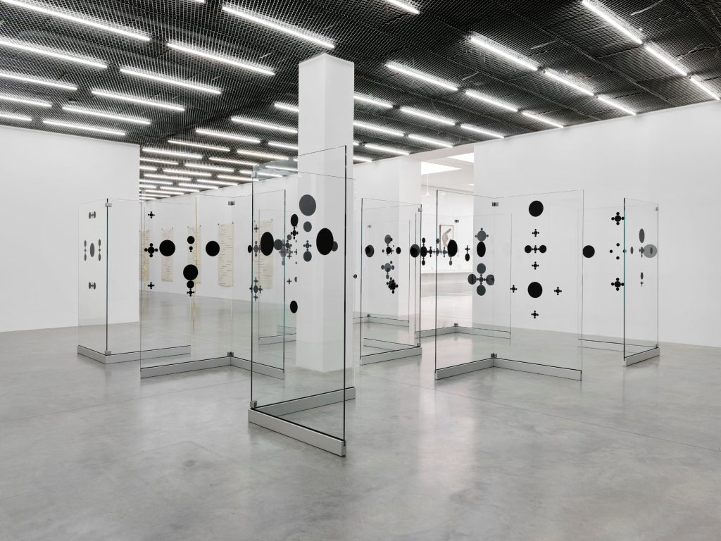 Glass panels with black discs in a gallery